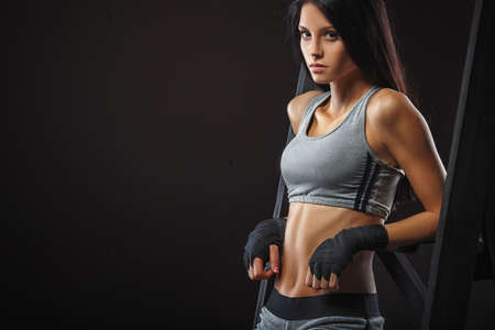 beutiful brunette woman boxer standing near ladder over dark background closeup viewの写真素材