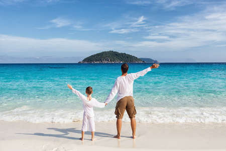Happy father and son playing together at tropical beachの写真素材