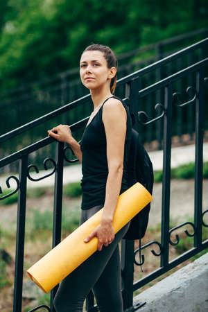 woman with a yoga mat outdoors. Concept of healthy lifestyle, yoga and sportsの写真素材