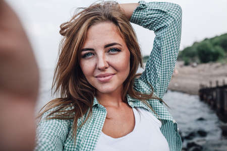 beautiful young adult woman taking picture of herself, selfie.の写真素材