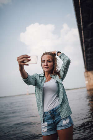 beautiful young adult woman taking picture of herself, selfie.の写真素材