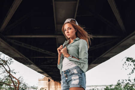 fashion beautiful girl posing under the bridge