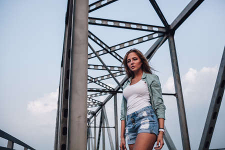young adult beautiful  fashion woman standing on bridgeの写真素材