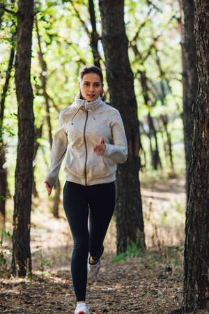 runner caucasian woman jogging in autumn parkの写真素材