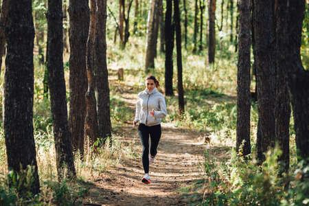 runner caucasian woman jogging in autumn parkの写真素材