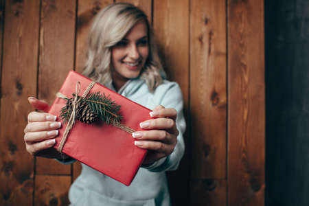 out of focus blonde woman  holding christmas giftbox, rustic style, film effects colorの写真素材