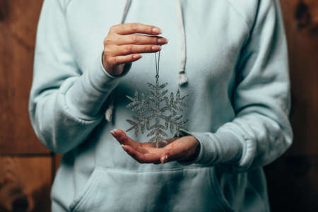 woman hands holding snowflake toy for christmas decoration