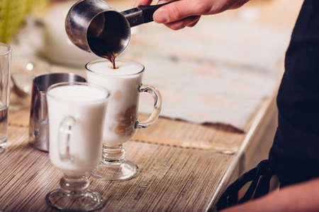 barista making latte , hand and two cups in the pictureの写真素材