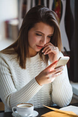 woman using her smartphone phone at cafeの写真素材