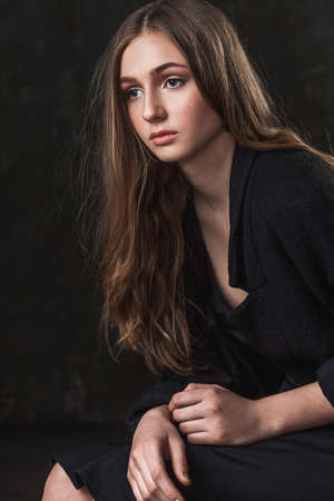portrait of a girl with sad eyes over dark backgroundの写真素材