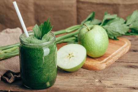 Green smoothie with celery and apple on rusic wooden tableの写真素材