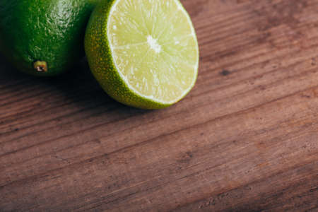green lime on wooden rustic table, copy space for textの写真素材