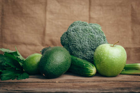 avocado, apple, lime, celery, cucumber broccoli wooden rustic table background front viewの写真素材
