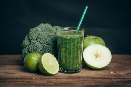 Smoothies and ingredients - avocado, apple, lime, celery, cucumber broccoli wooden rustic table...