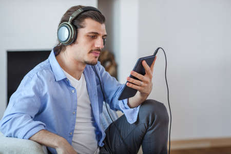Handsome guy listening to music on internet with tabletの写真素材