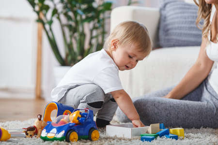 cute mother and child boy play together indoors at home