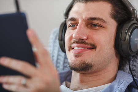 Handsome guy listening to music on internet with tabletの写真素材