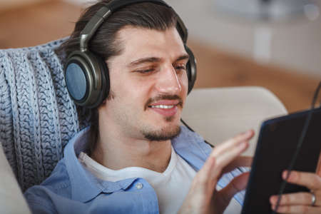 Handsome guy listening to music on internet with tabletの写真素材