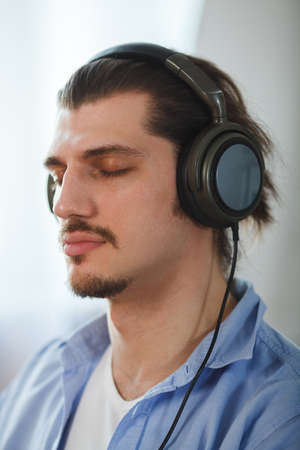 Music in his mind. Portrait of young man wearing headphones and closed eyesの写真素材