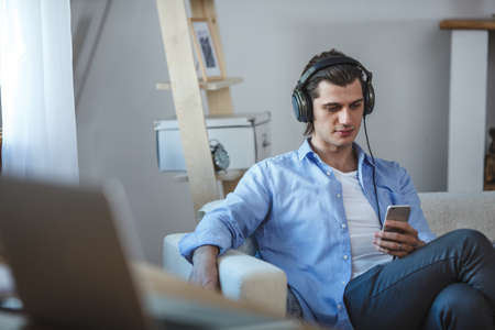 Handsome guy listening to music on internet with smartphoneの写真素材