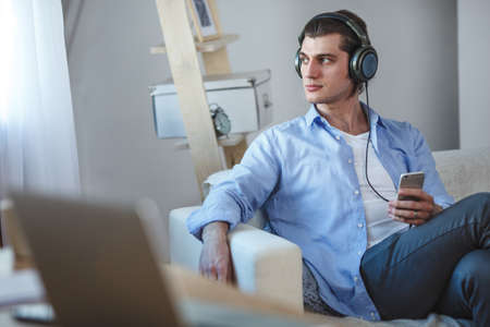 Handsome guy listening to music on internet with smartphoneの写真素材