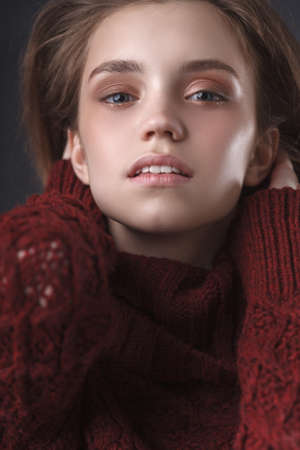 young teenage blonde girl closeup portrait over dark backgroundの写真素材