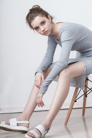 young teenage girl model sitting on the chairの写真素材