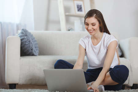 beautiful ypung woman using laptop at homeの写真素材