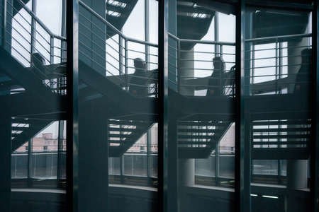 reflection of woman on stairs in the glassの写真素材