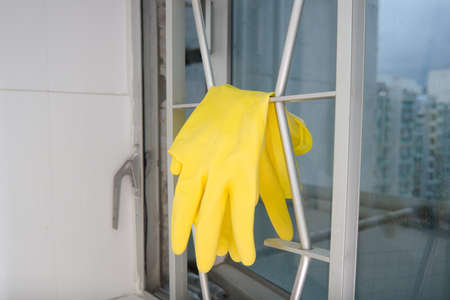 Drying yellow gloves on the window grillesの写真素材