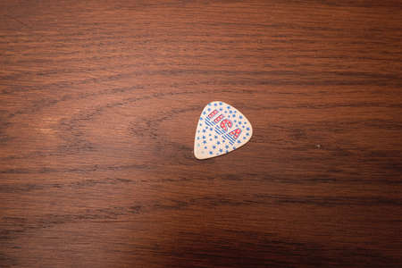 Isolated guitar pick on a wooden table background with copy spaceの写真素材