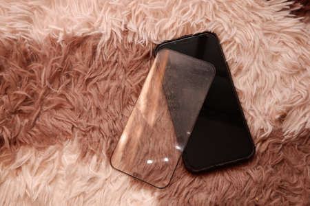 Cracked smart phone screen protector film on carpetの写真素材