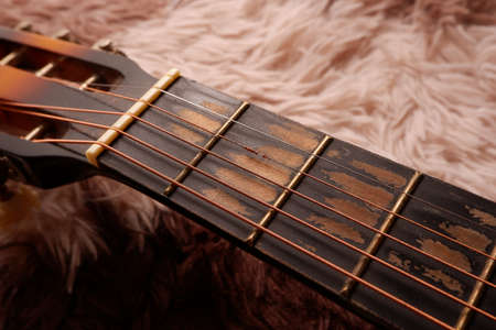 Used guitar with broken metal string on a carpetの写真素材