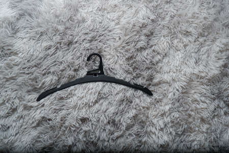 Single empty black hanger on gray background