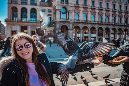 Pigeons flying near people in central square, Milanの写真素材