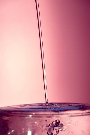 Water splash isolated on pink graduated background, water bubble, detailed picture, natural elements.の写真素材
