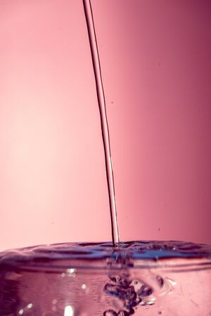Water splash isolated on pink graduated background, water bubble, detailed picture, natural elements.の写真素材