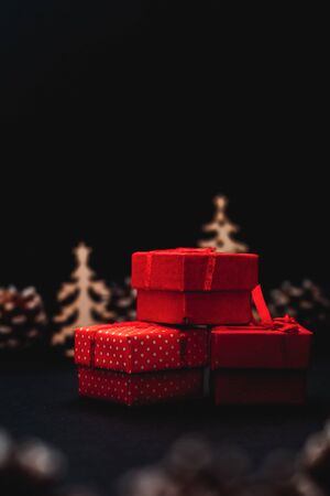 Small red gift boxes on black background, christmas decoration, christmas gifts, christmas picture for social media, empty space for textの写真素材