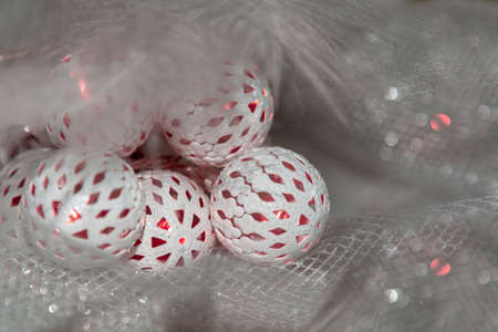 A Christmas and New Year glowing garland with white balls lies on a table covered with a cloth.の写真素材