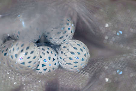 A Christmas and New Year glowing garland with white balls lies on a table covered with a cloth.の写真素材