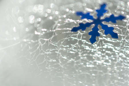 Christmas and New Year. Snowflake against the background of cracked ice. Christmas festive backgroundの写真素材