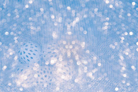 A Christmas and New Year glowing garland with white balls lies on a table covered with a cloth.の写真素材