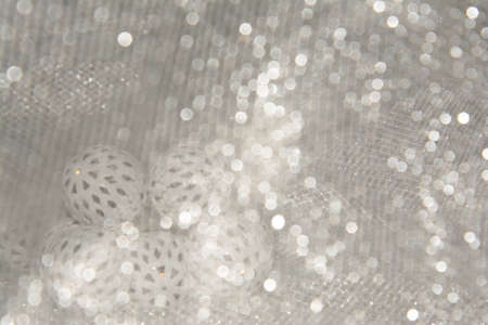 A Christmas and New Year glowing garland with white balls lies on a table covered with a cloth.の写真素材