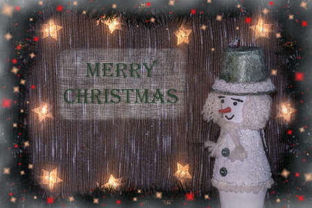 New Years and Christmas. Festive Christmas background with snowman and the inscription of a Merry Christmas.の写真素材