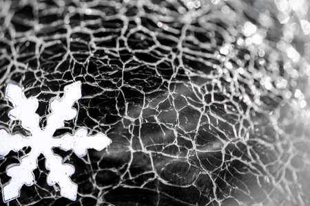Christmas and New Year. Snowflake against the background of cracked iceの写真素材