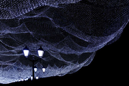 Christmas illumination of the night city. White lights, lights on a dark street.の写真素材