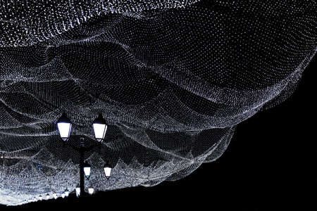 Christmas illumination of the night city. White lights, lights on a dark street.の写真素材