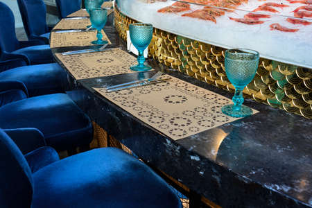 A served round table, located around the open kitchen in a fish restaurant.の写真素材