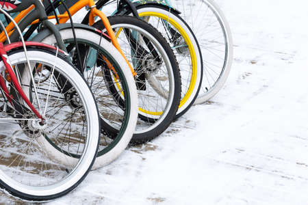 Close-up on the bright wheels of bicycles that stand on the snowの写真素材