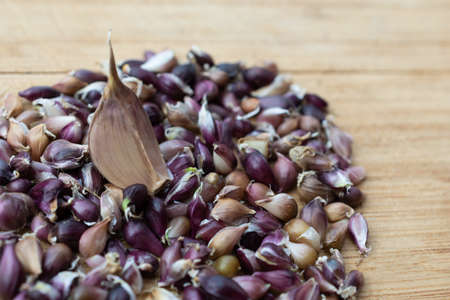 Garlic seeds are on a wooden board against the background of a clove of garlicの写真素材